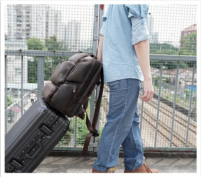 Dark brown retro genuine leather backpack for men, open to show laptop compartment and internal organisers.
