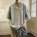 A grey men's loose-fit T-shirt with a retro style and raised 3D letter print on the chest.