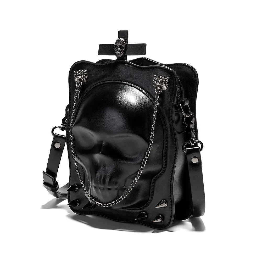 Black square crossbody bag with embossed skull design, chain accents, and zip opening