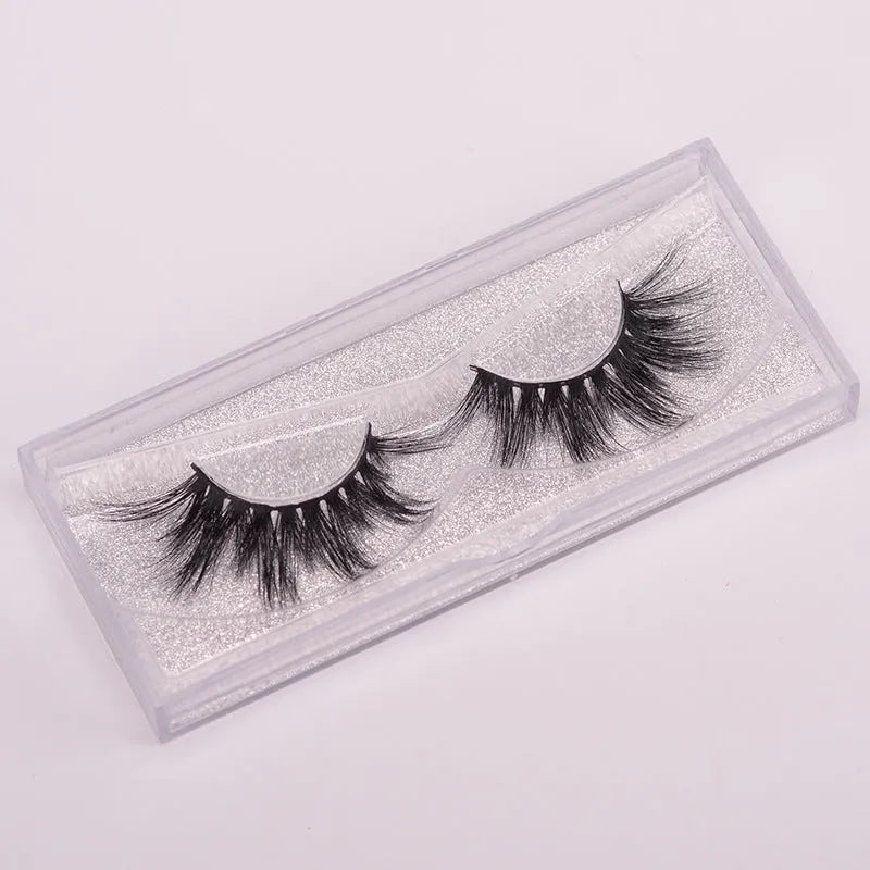 5D mink false eyelashes set with hair storage cap and double-headed brush on a clean surface.