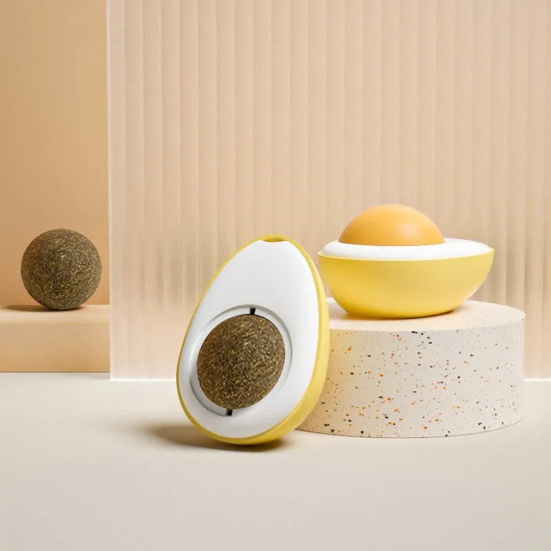 Soft plush catnip ball toy with adhesive base sticking to a wall for interactive feline play