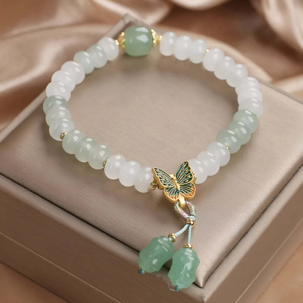 Green crystal abacus bead bracelet with butterfly charm and tassel detail, 17 cm length