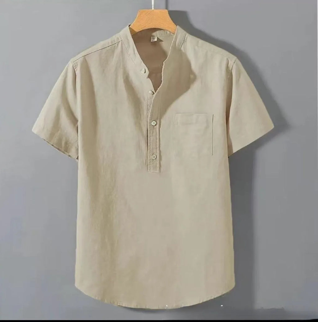 Man wearing a beige loose-fit short sleeve linen shirt with a stand collar.