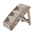 Foldable grey pet stairs with non-slip mats placed next to a sofa for a small dog.