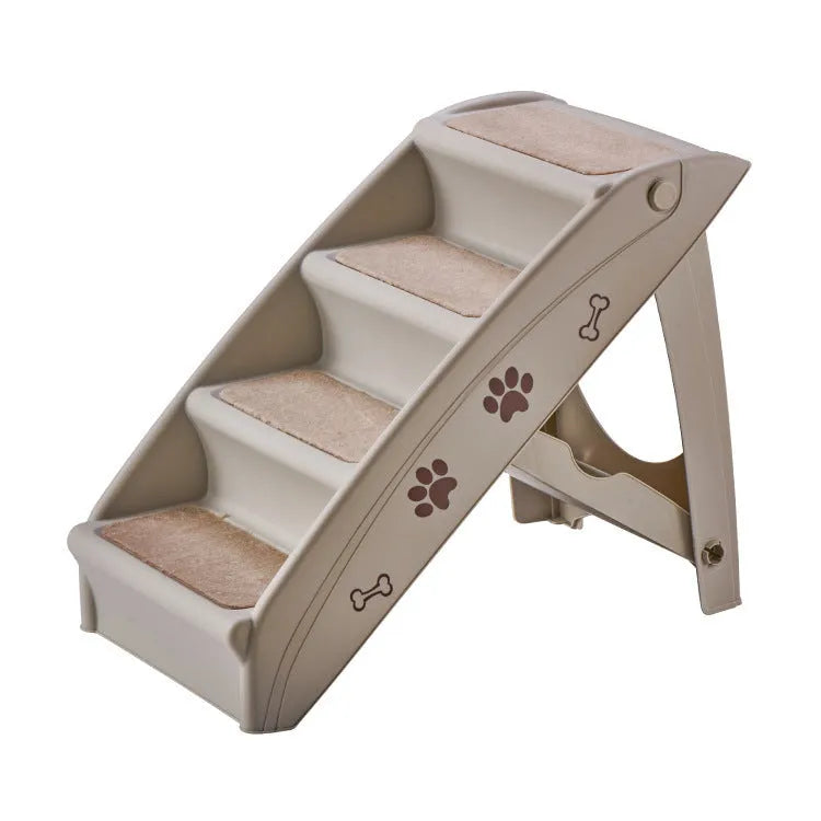 Foldable grey pet stairs with non-slip mats placed next to a sofa for a small dog.