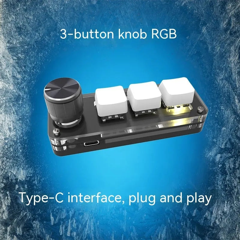 Compact black USB keypad with RGB colourful backlighting on a desk.