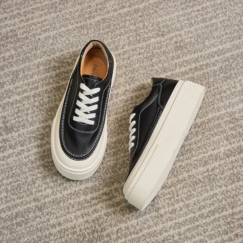 Women's black embossed leather platform sports shoes with round toe and white rubber sole on a white background.