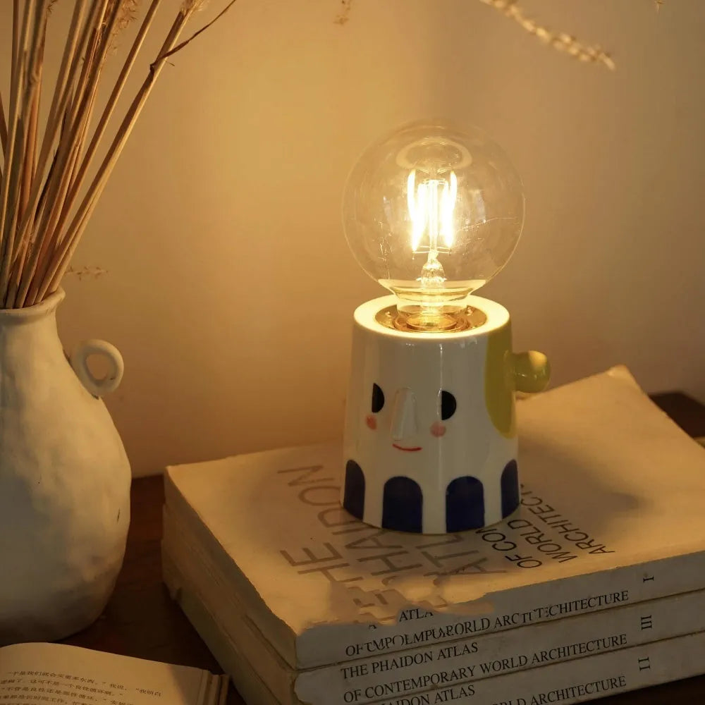 Handmade ceramic bedside lamp with ball headlight design on wooden surface