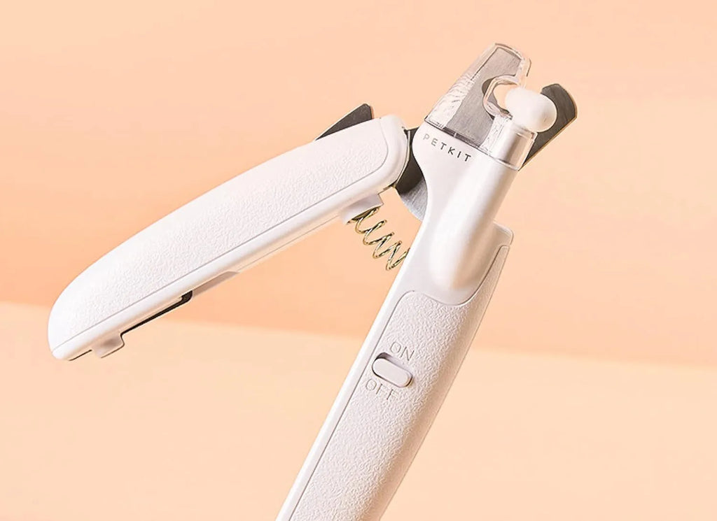 White LED pet nail clippers for dogs and cats with a transparent safety guard and leather-like handle.