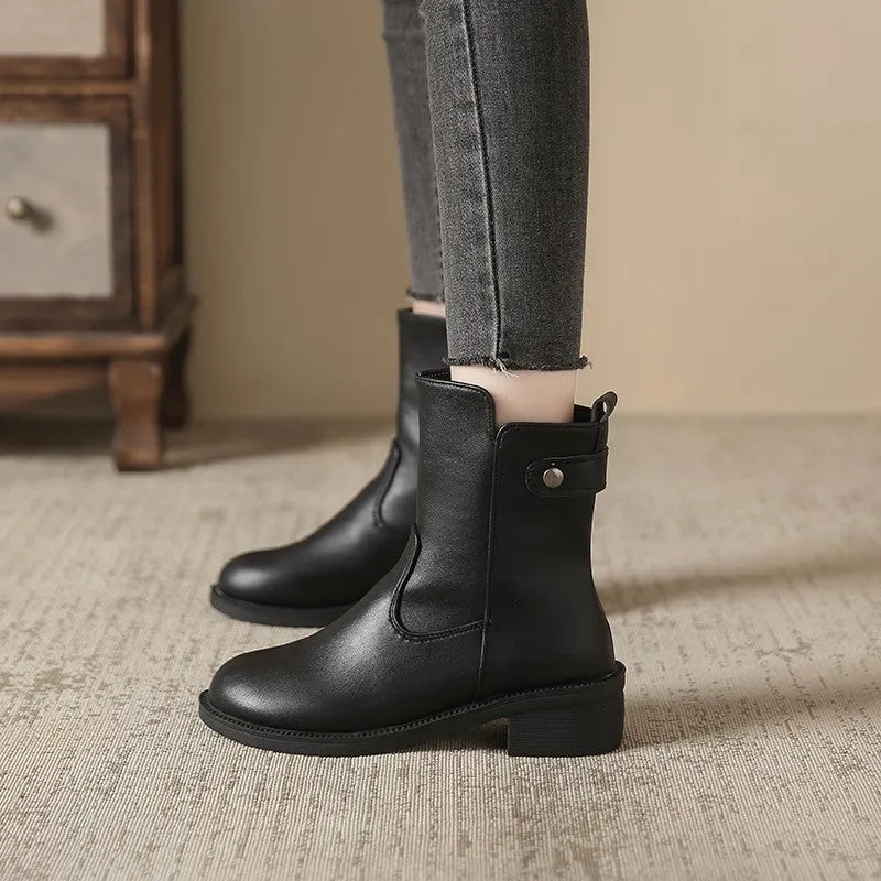 Black women's ankle boots with a side zip, round toe, and low rubber sole.