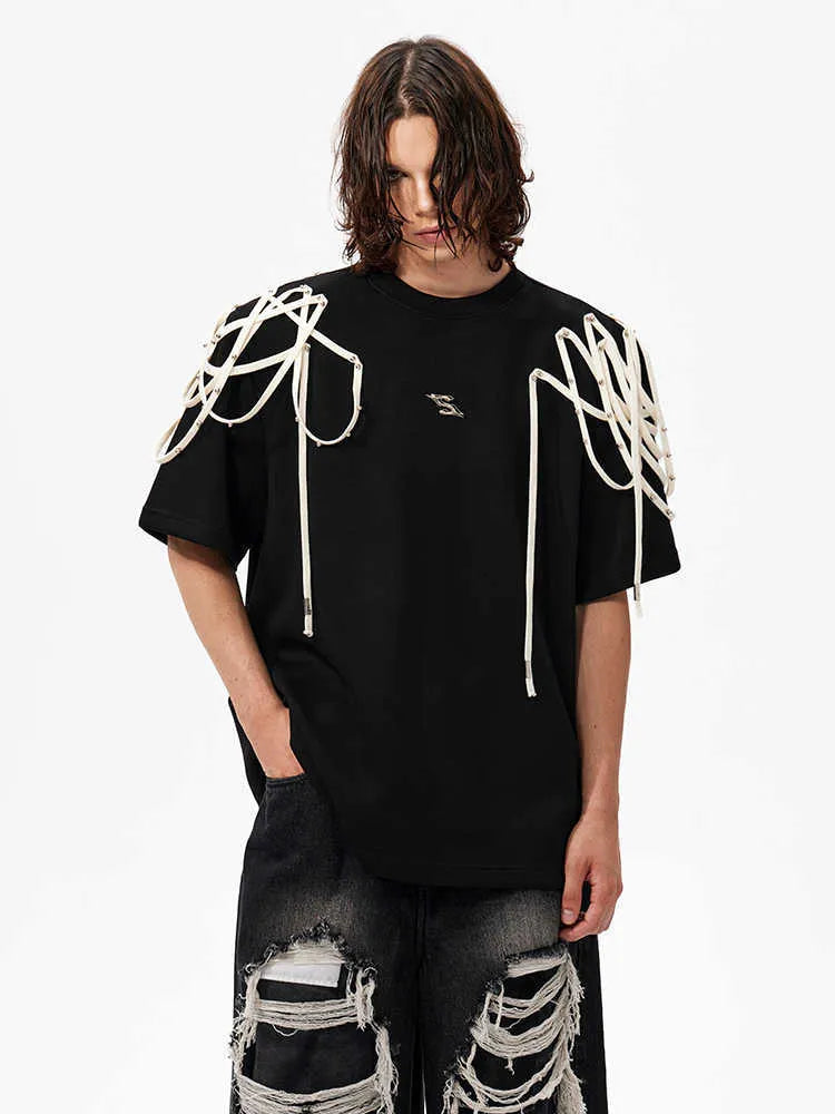 Black loose fit T-shirt with padded shoulders featuring decorative rivet detailing and ribbed texture