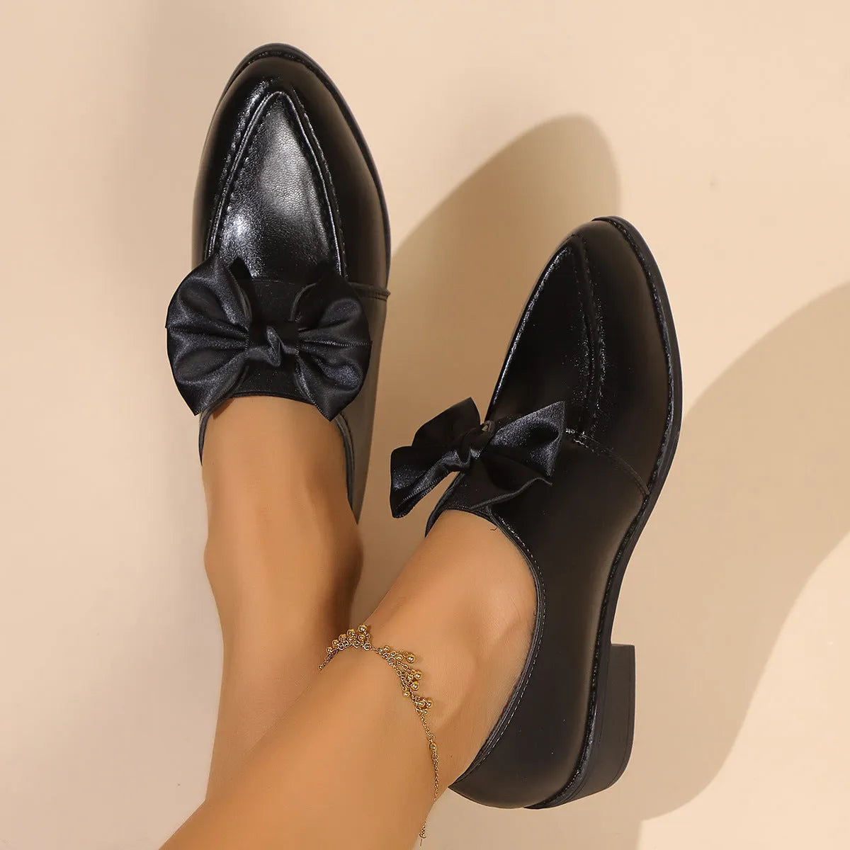 Women's British-style flat shoes with decorative bow, PU upper, and rubber sole in sizes 36-43.