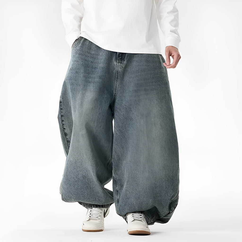 Man wearing light blue plus-size wide-leg casual denim jeans with a baggy fit and straight leg opening.