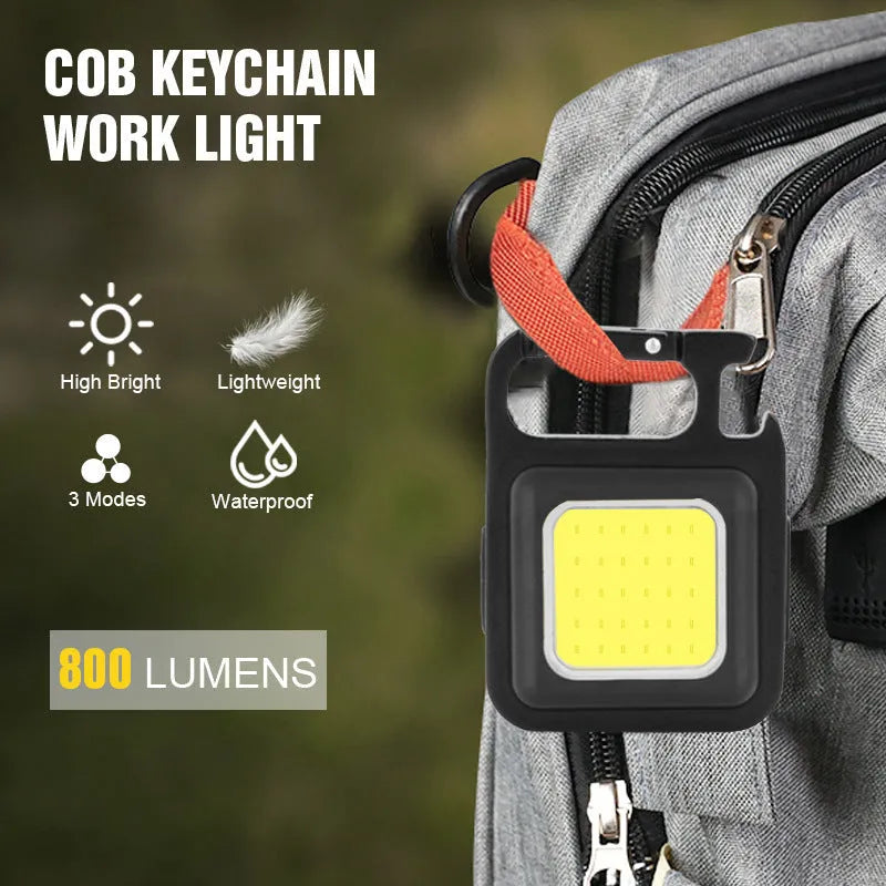 Black aluminium alloy USB rechargeable keychain torch with magnetic base and foldable handle.