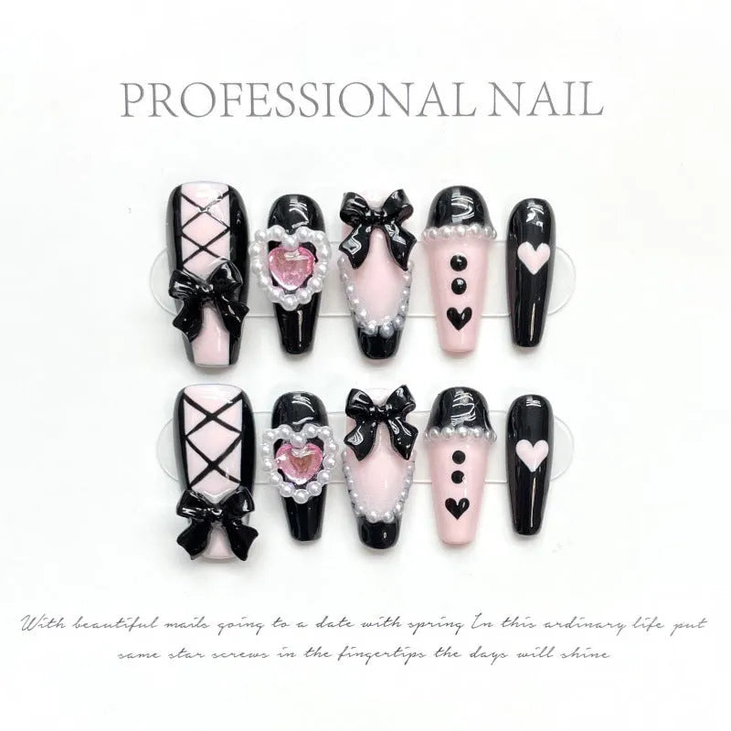 Detachable artificial nails with hand-painted black and pink heart design and cat's eye finish in four sizes