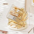 Rotating clear plastic cosmetic storage box organiser on a table.