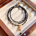 Close-up of a women's multi-layer bracelet with three interlinked rings made from blue and gold cut sand stone.