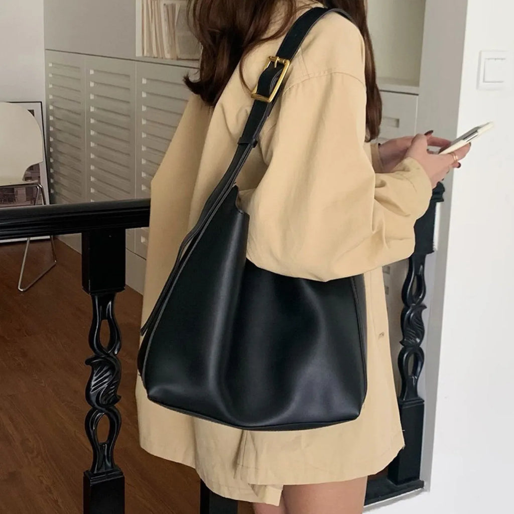 Women's soft PU leather shoulder bag with swing threads design in black or brown, showing 28x32x12cm dimensions