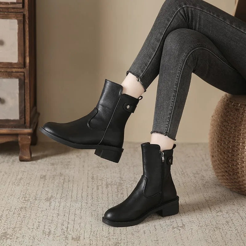 Black women's ankle boots with a side zip, round toe, and low rubber sole.