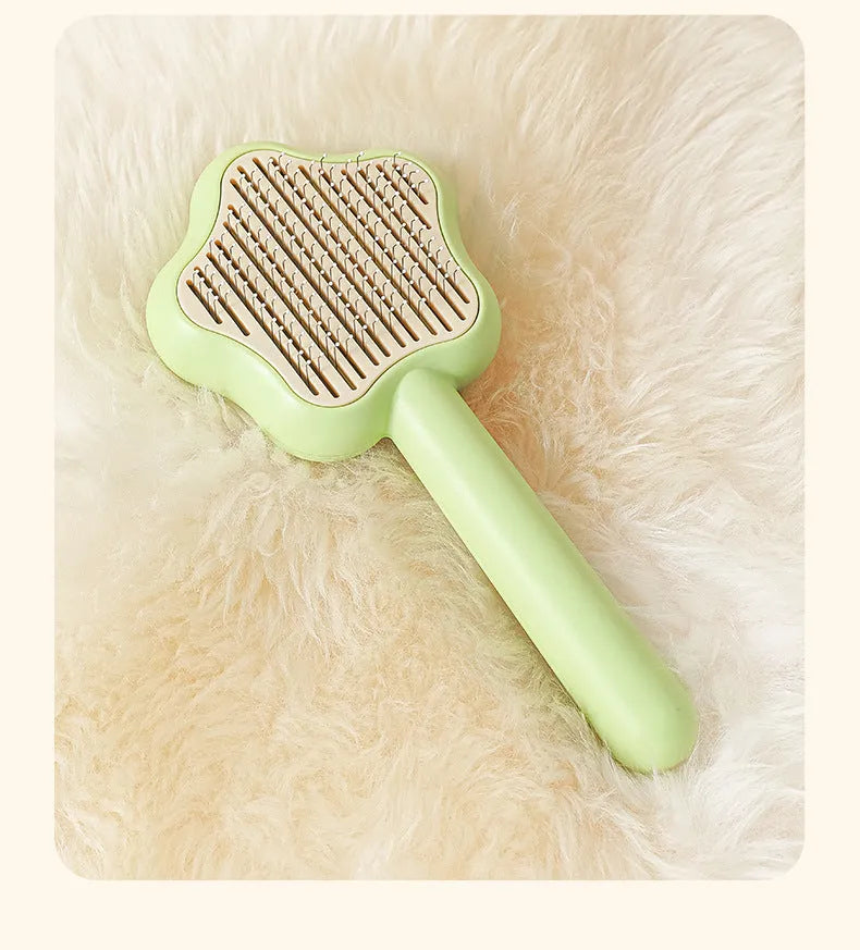 Green self-cleaning stainless steel cat comb with needle teeth on a 20cm handle.