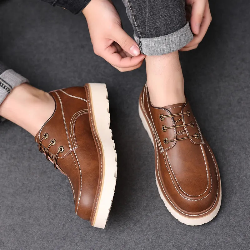 Men's black low-top Martin boots with round toe and rubber sole on a neutral background.