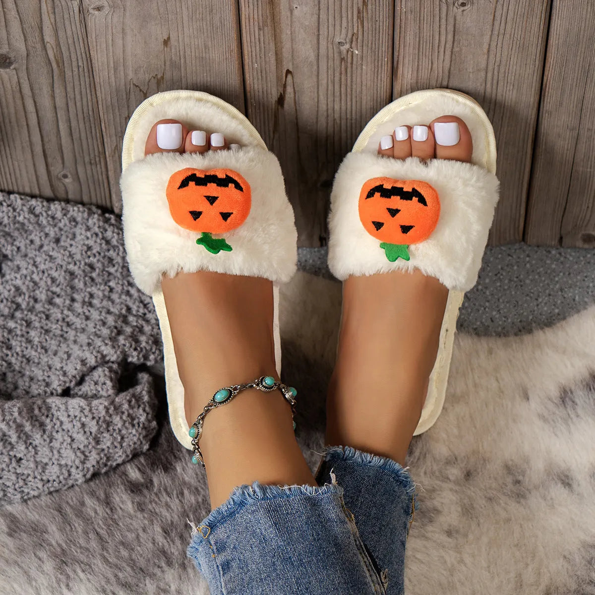 Yellow and white Halloween pumpkin cartoon design plush slippers with an open toe and textured sole.