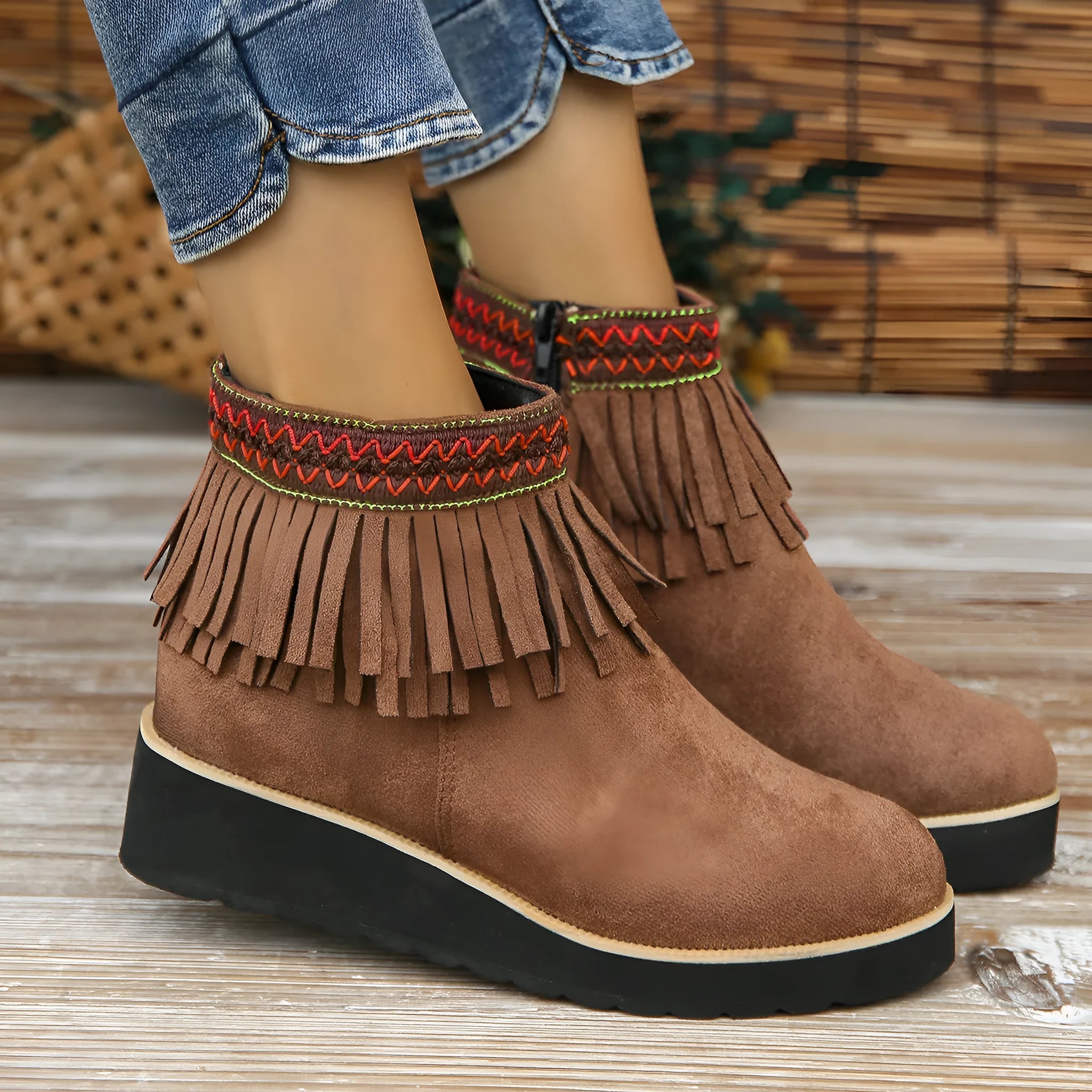 Women's suede ankle boot with wedge heel, side zipper, tassel detail, and thick rubber sole in three colour options.