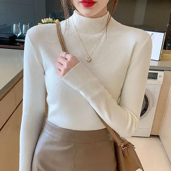Women's slim fit long sleeve viscose knit top in a neutral colour on a hanger.