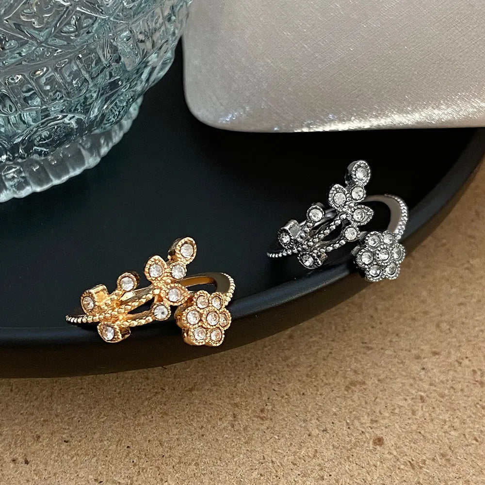 Women's open back copper ring with floral leaf design in a white diamond finish.