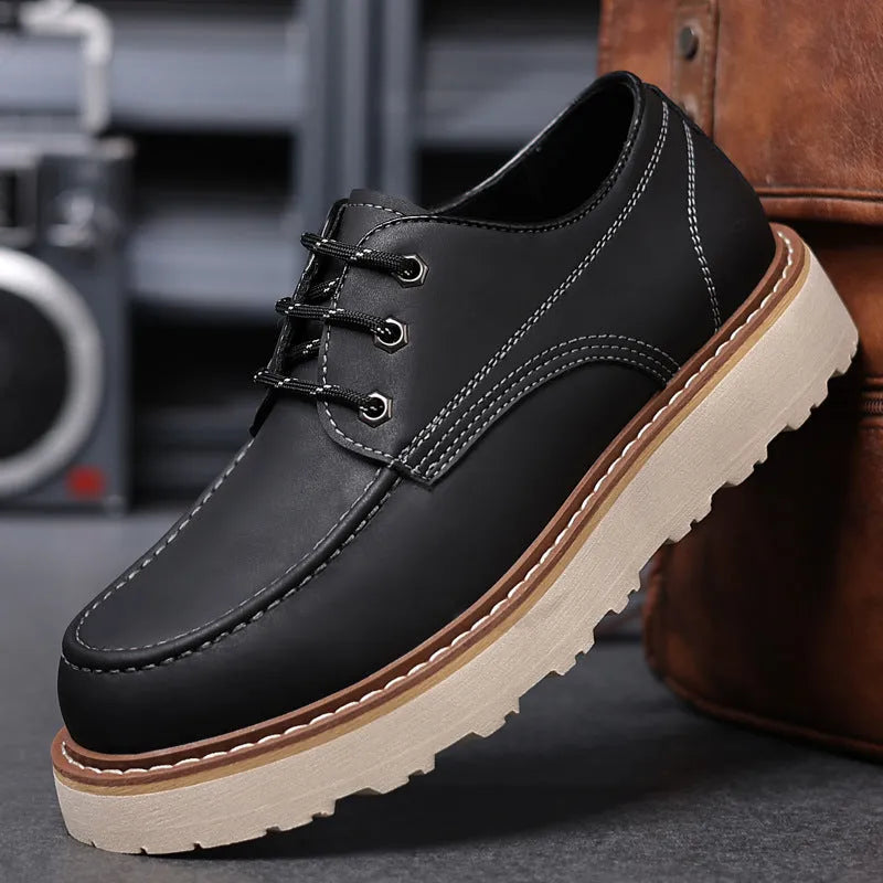 Men's black low-top Martin boots with round toe and rubber sole on a neutral background.