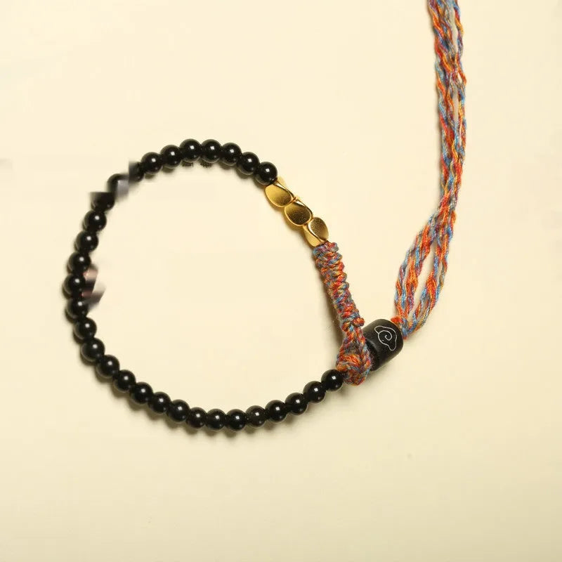 Hand-woven obsidian stone bracelet on a wrist, showing its dark colour and 4mm width.