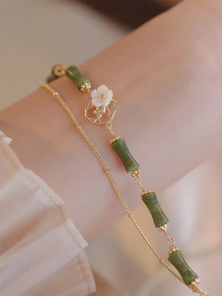 Natural olivine women's bracelet with a double layer twin bells of ireland charm and olive branch detail.