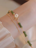 Natural olivine women's bracelet with a double layer twin bells of ireland charm and olive branch detail.