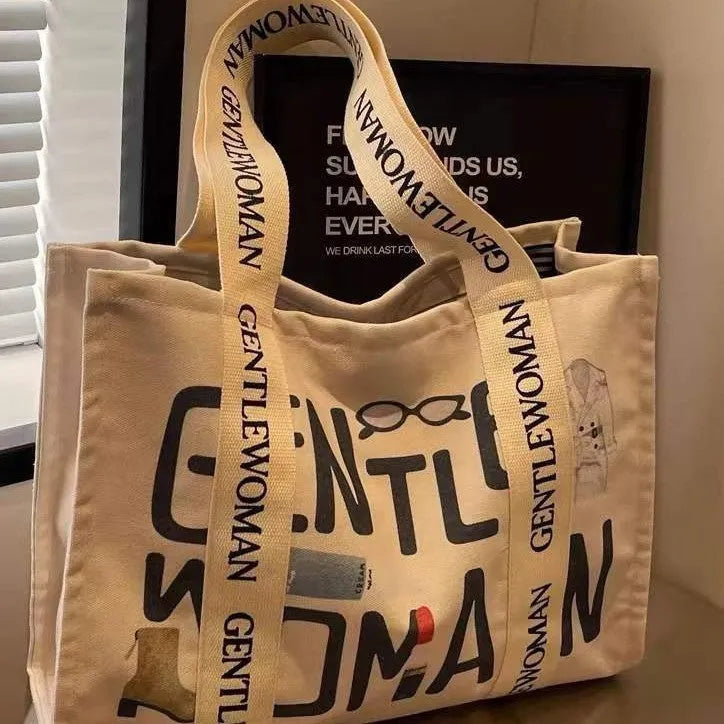 Large canvas tote bag with printed design options including letters and patterns.