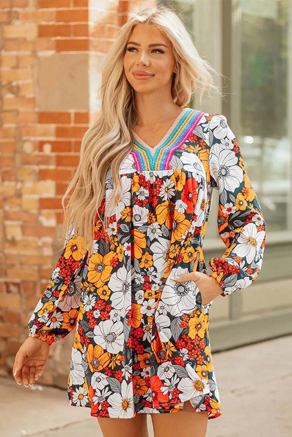 Orange floral print V-neck mini dress with long lace sleeves on a mannequin.