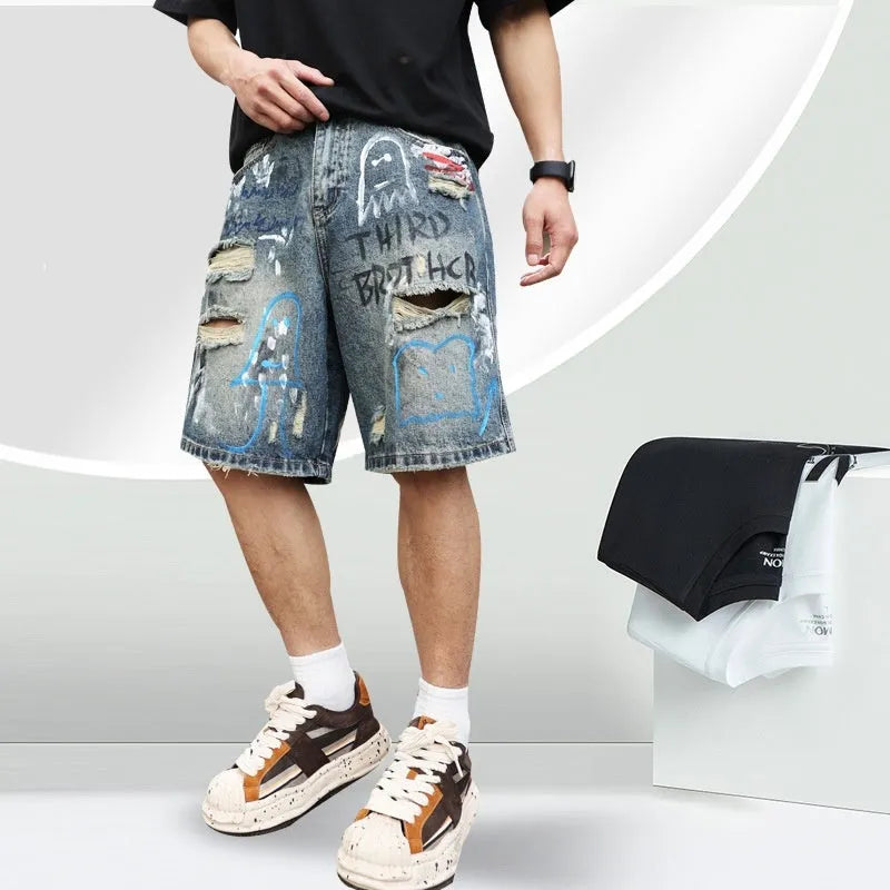 Blue men's denim jeans shorts with graffiti print and ripped details, showing straight leg and zipper fly.