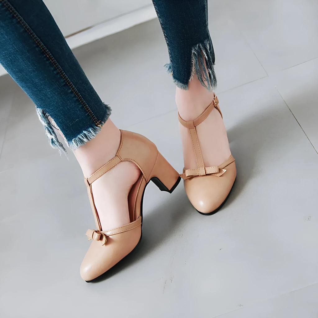 Women's apricot chunky heel sandals with a bow detail and hollow-out sides on a white background.