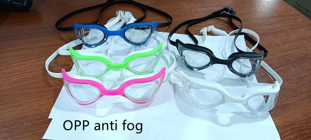 Close-up of racing style anti-fog swimming goggles with a silicone seal on a dark background.