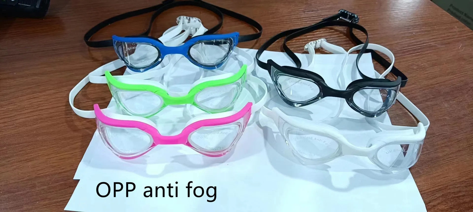 Close-up of racing style anti-fog swimming goggles with a silicone seal on a dark background.