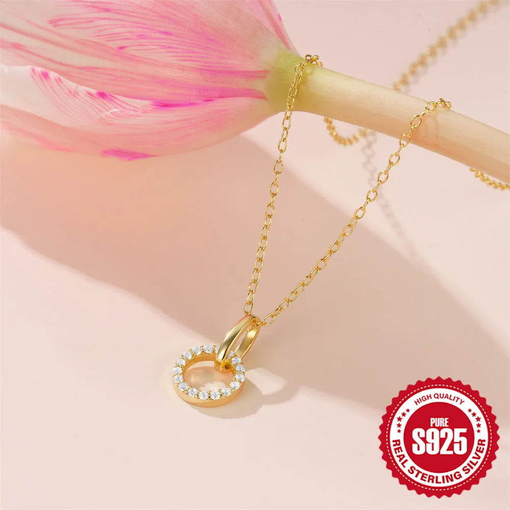 Gold-coloured sterling silver adjustable clavicle chain with interlocking geometric zircon pendant.