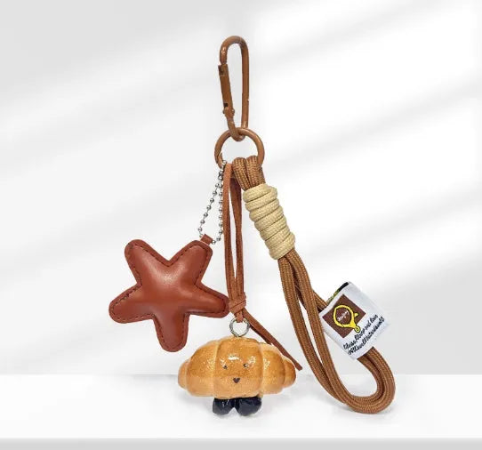 Handmade soda bread style resin handbag pendant with brown strap and food designs.