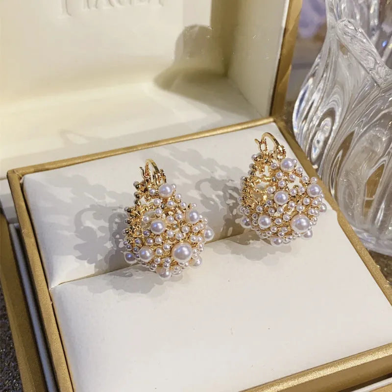Gold-coloured copper basket flower earrings with pearl inlay and small rice-shaped bead detailing