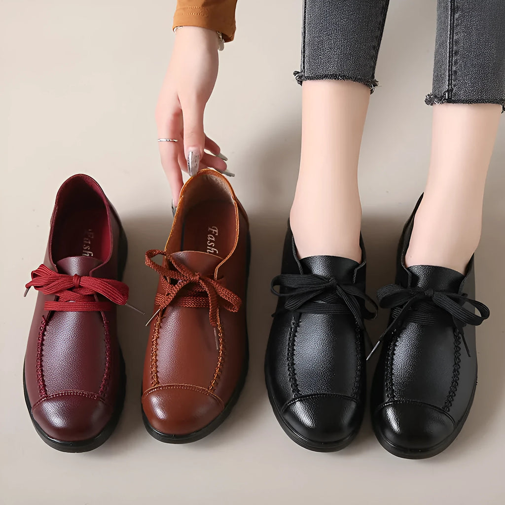 Women's black flat work shoes with round toe, front lacing, and soft anti-slip polyurethane sole