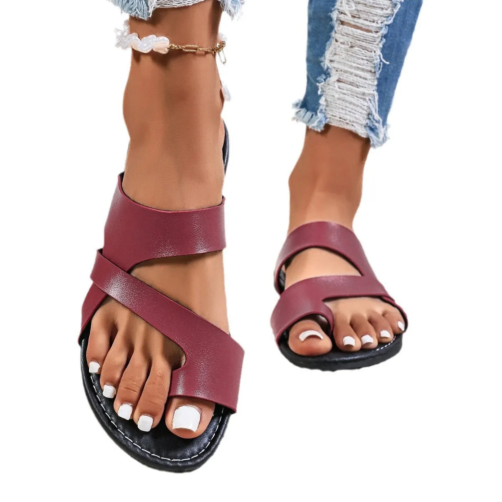 Men's simple one-line beach slippers in black with a round head and hollow-out design on a rubber sole.