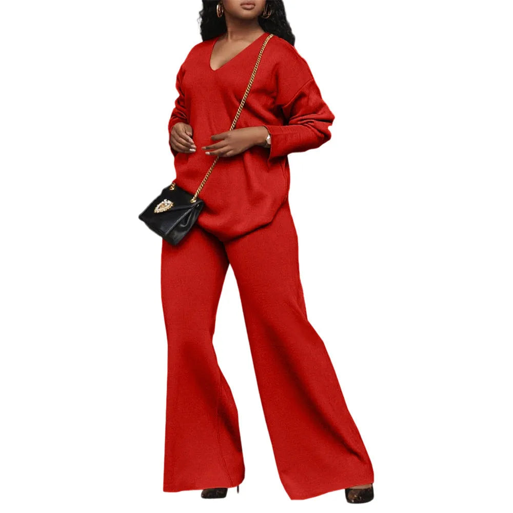 Women's brown suede two-piece suit with split sleeve top and full-length trousers on a model.