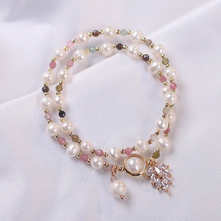 Women's double layer crystal bracelet with lucky cat charm and red cat's eye flowers.