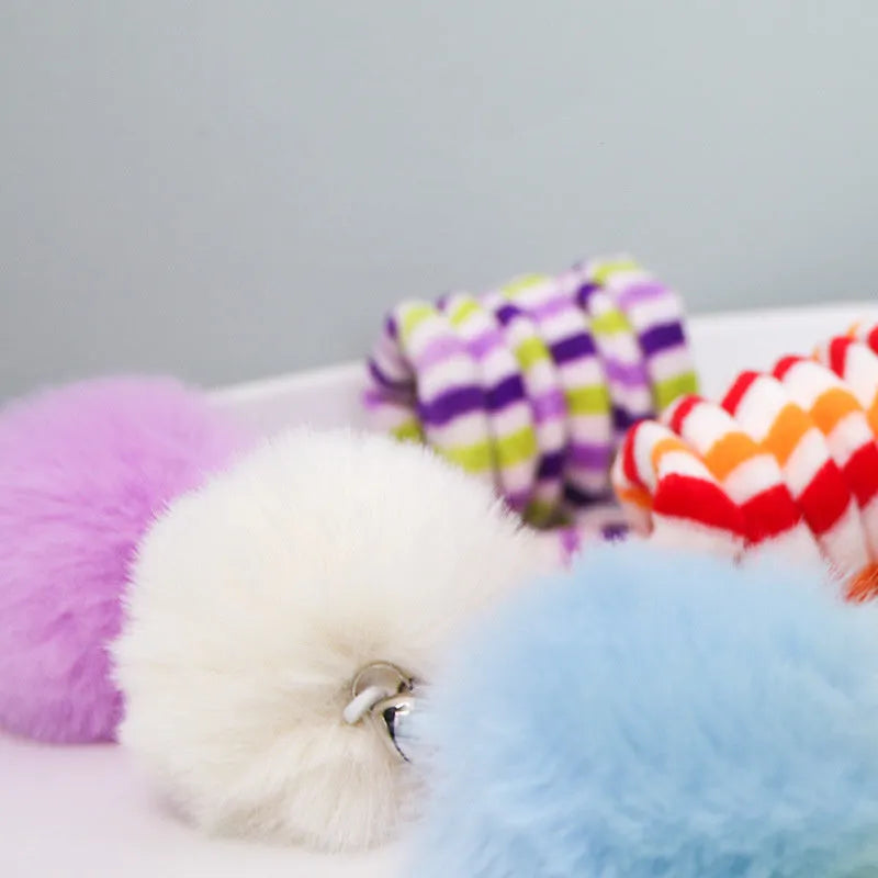 Hanging cat toy with coloured bell stick and inflatable ball attached by suction cup to a door