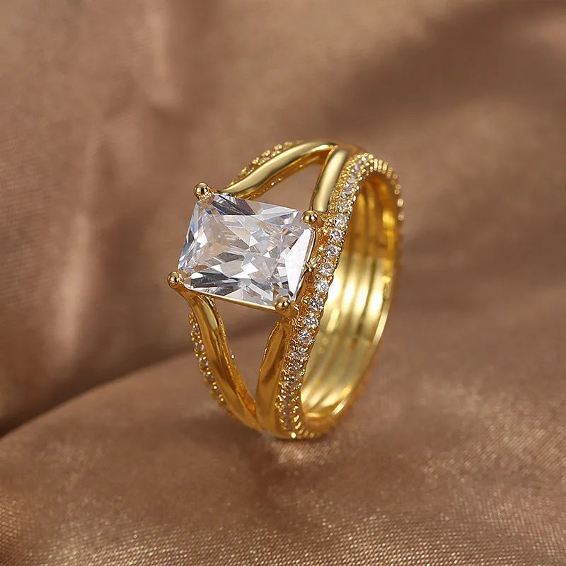 Geometric gold-coloured women's ring with a square zircon stone, shown in size options 6 to 9.