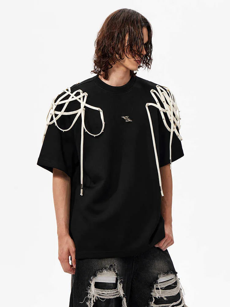 Black loose fit T-shirt with padded shoulders featuring decorative rivet detailing and ribbed texture