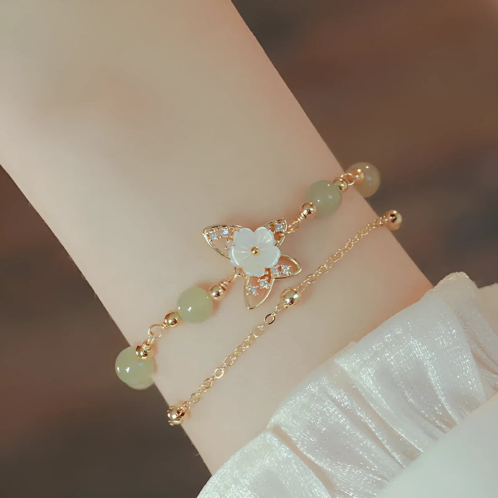 Yellow gold electroplated copper bracelet with genuine Hetian jade Bells of Ireland butterfly charm for women.
